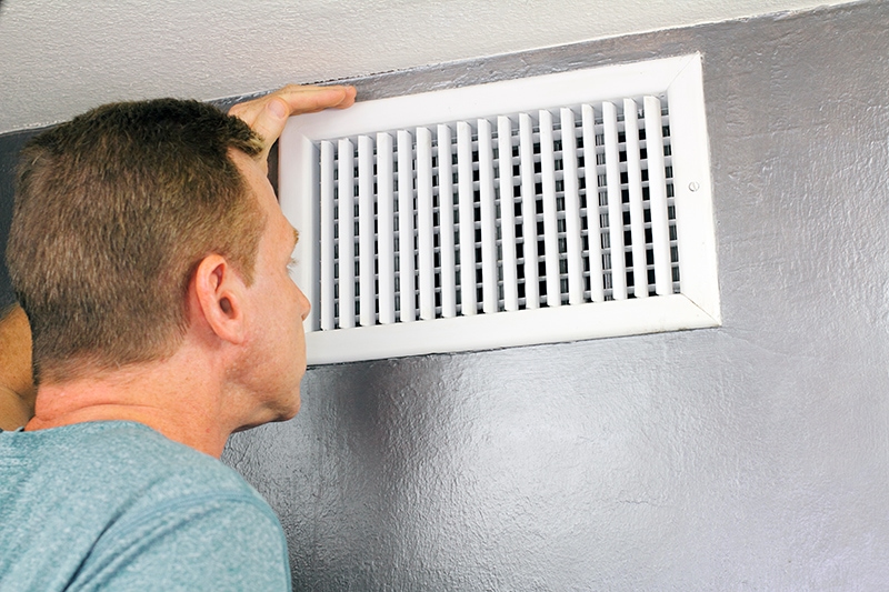 Technician performing AC maintenance in Spring, TX. Milton Frank Plumbing & Cooling blog image.