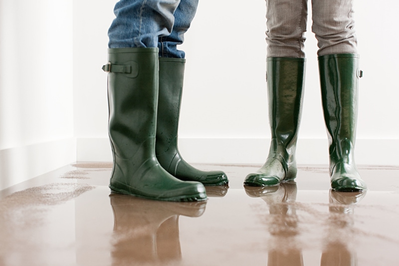 5 Signs of a Major Plumbing Problem. Two pairs of legs in green rain boots.