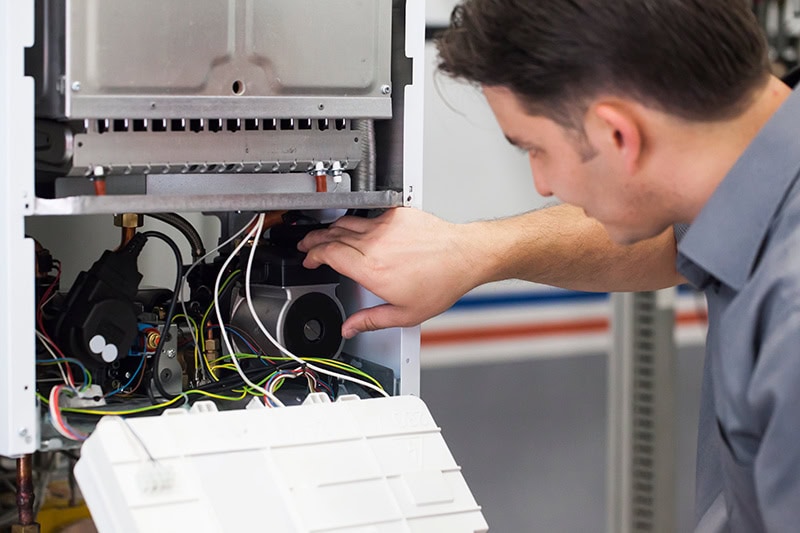 An HVAC technician fixing up a heat pump.