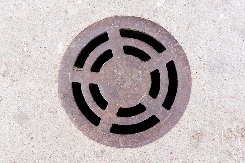 Prepare Your Spring, Plumbing for Holiday Gatherings. Metal drain cover texture.